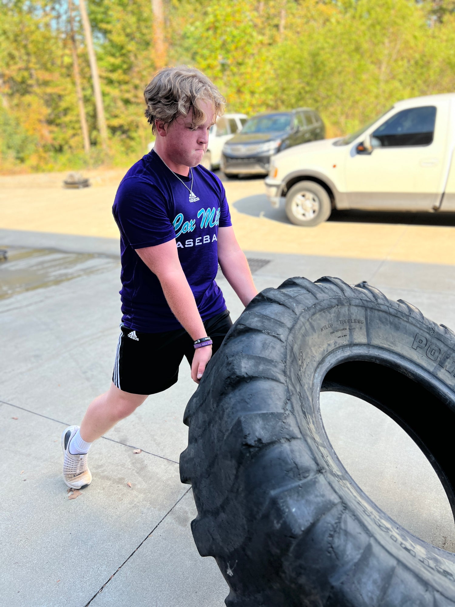man lifting a tire for exercise